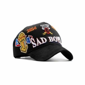 Vista 3/4 de gorra negra con múltiples bordados coloridos y logo frontal SAD BOYZ 3D.