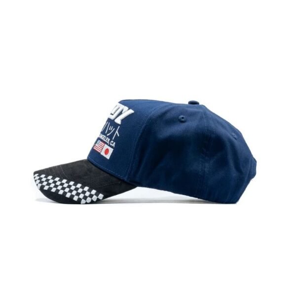 Gorra Dandy Hats Motorsports Blue vista lateral mostrando visera negra Vista lateral izquierda de gorra Dandy Hats azul con visera gamuzada negra y diseño automovilístico