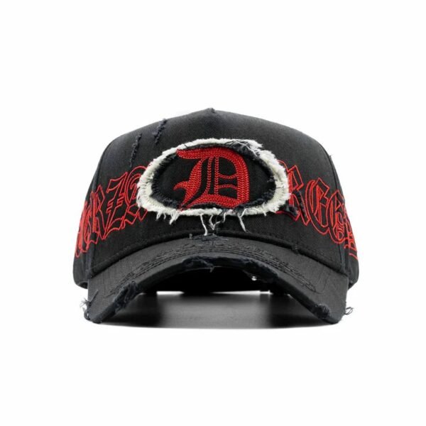 Gorra Dandy x Fuerza Regida “Distressed” - Diseño Gótico con Letra D Gorra negra con parche rasgado al frente, letra D roja bordada y texto REGIDA, estilo urbano de la colección Dandy x Fuerza Regida.