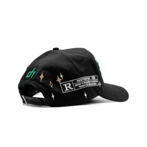 Gorra The Dandy Club – Detalle trasero con parche “Restricted” Vista trasera de la gorra con diseño tipo etiqueta de clasificación “R Restricted”