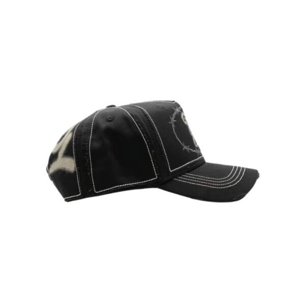 Gorra Rodeo DandyWood - Vista Lateral Izquierda Perfil lateral izquierdo de la gorra DandyWood Rodeo, mostrando diseño en spray y estructura de paneles negros con costuras blancas.