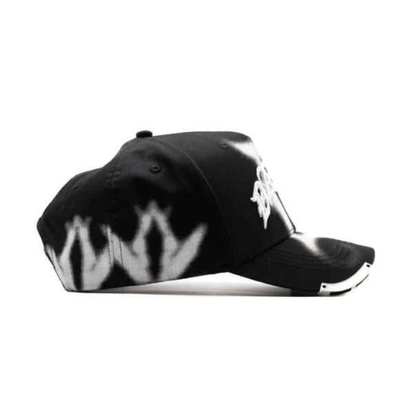 Lado derecho con detalles gráficos Vista lateral derecha de gorra negra con efecto de aerosol blanco y texto bordado