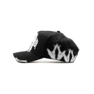 Vista lateral izquierda de gorra negra con patrón blanco de aerosol en forma de corona
